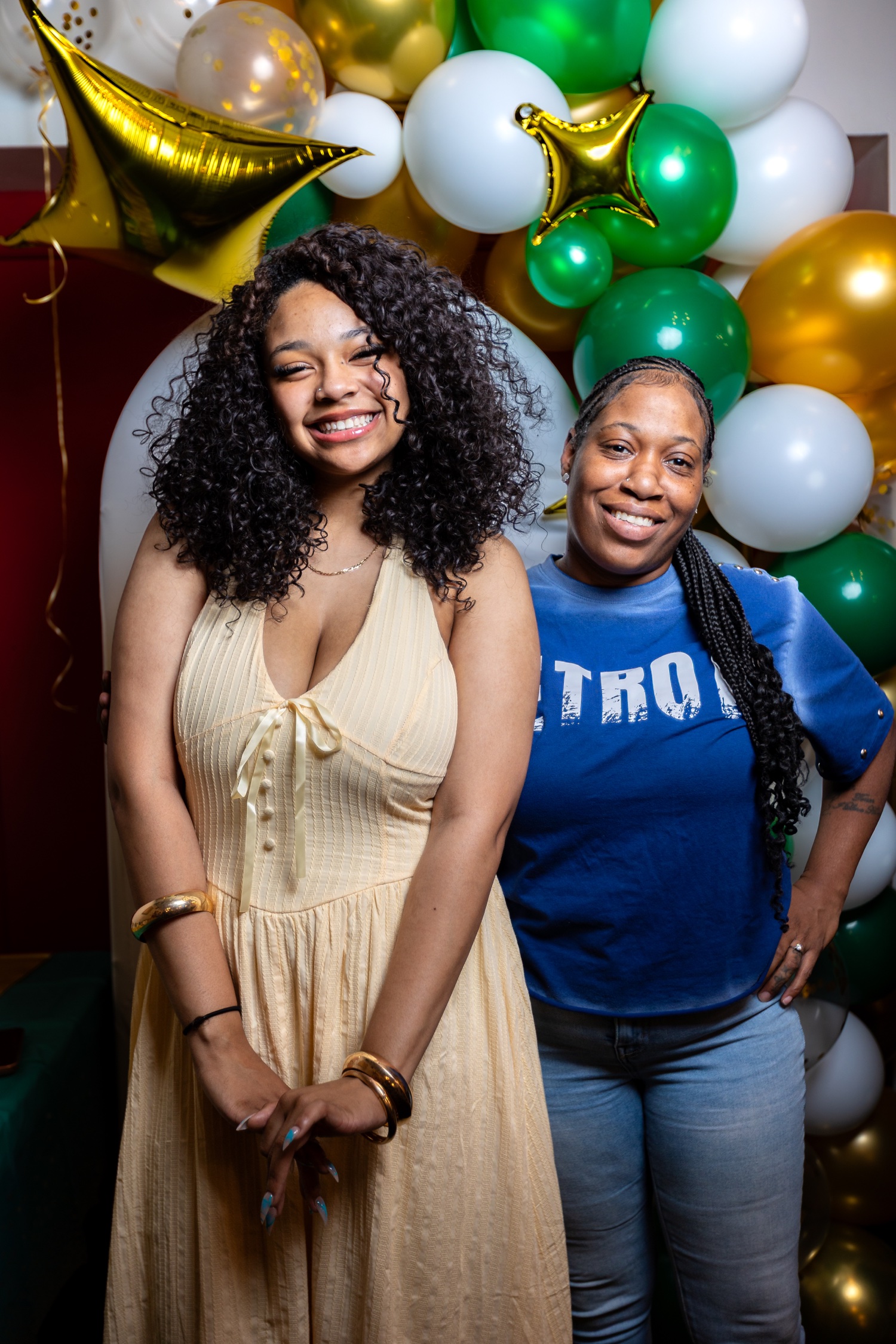 Detroit graduation party photography with family in front of green, gold, and white balloons